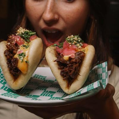 Person preparing to eat two stuffed buns.