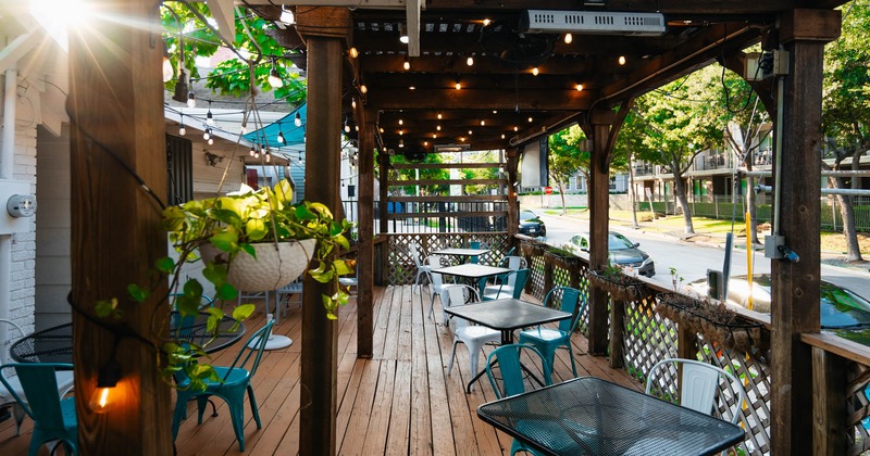 Exterior, partially covered seating area, metal chairs and tables, floral decoration