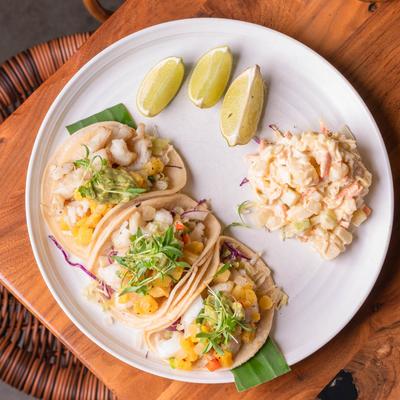 Fish tacos, with pineapple salsa, cabbage, lime, avocado, and a side of pineapple coleslaw.