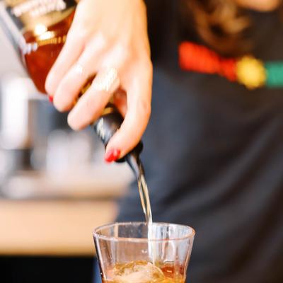 Bartender pouring liquor into a glass of ice.
