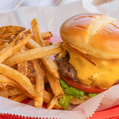 Cheeseburger with lettuce, tomato and a side of fries.