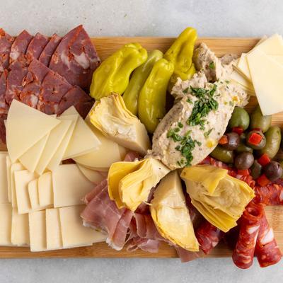 Antipasto platter with cured meats, cheeses, olives, artichoke hearts and pepperoncini.