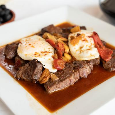 Portuguese-style steak in pan sauce topped with fried eggs.
