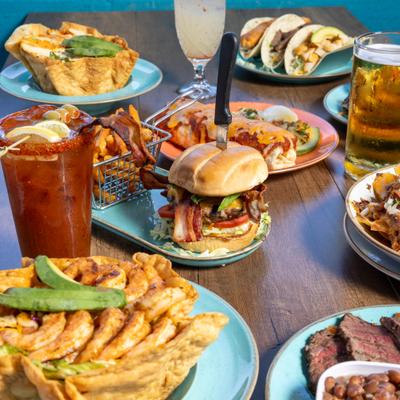 Assortment of dishes served on the table alongside cocktails.