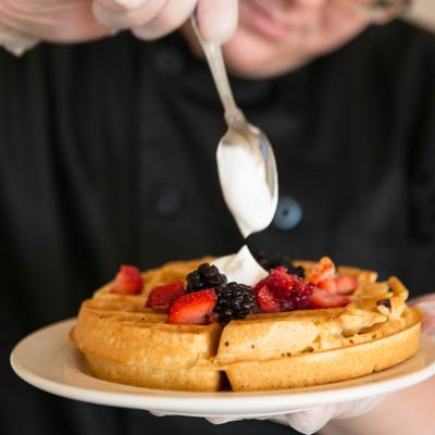 Waffle, topped with whipped cream and berries.