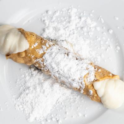 Cannoli topped with powdered and filled with cream.