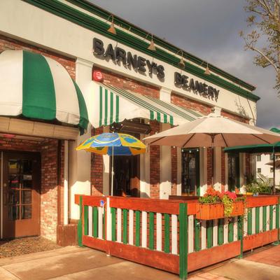 The exterior of Barney's Beanery  with striped awnings and umbrellas