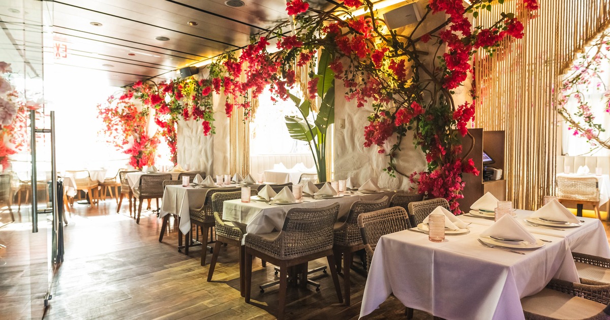 Interior dining area with white tablecloth tables and flower arrangements