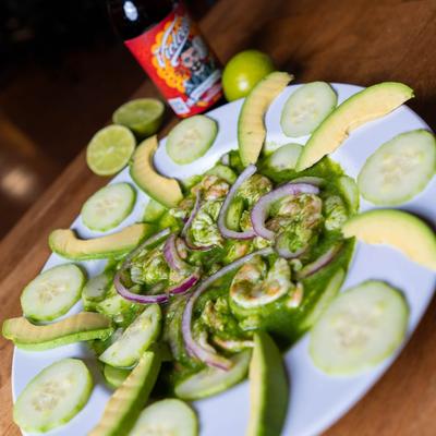 A plate with Aguachile Verde and a bottle of beer.