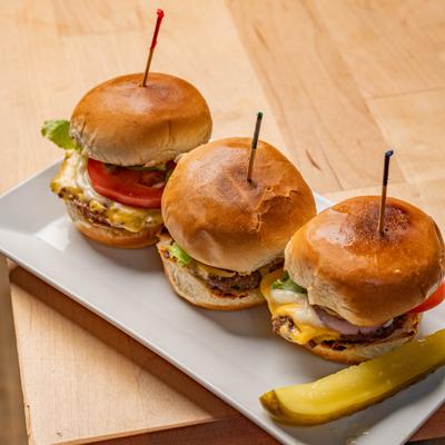 Cheeseburger Sliders served on a plate with a pickle.