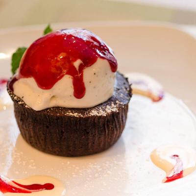 Ice cream, served on a cupcake with sauce on top