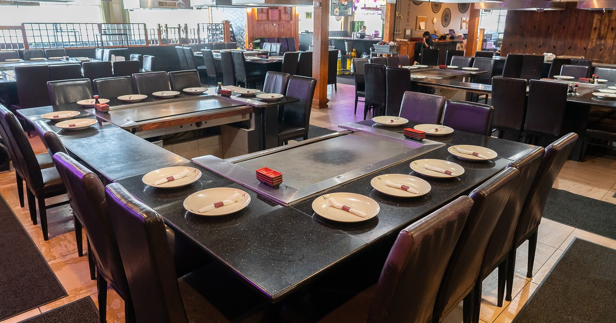 Interior of a Japanese hibachi style restaurant with large teppanyaki grill tables