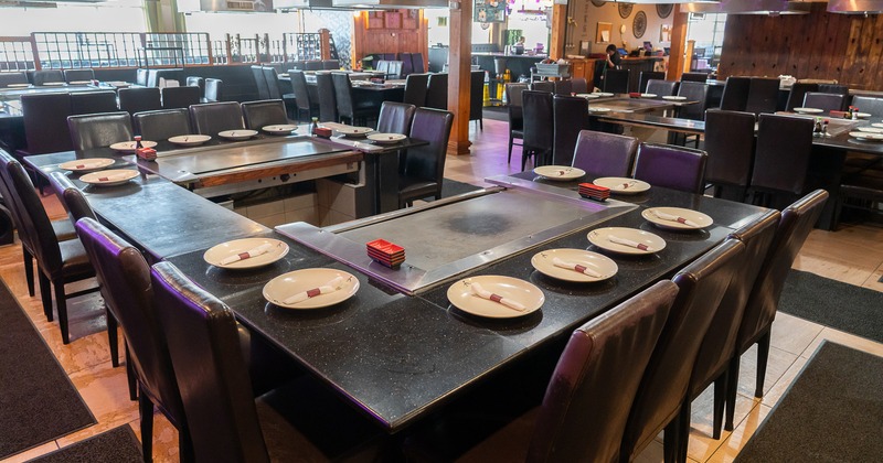 Interior of a Japanese hibachi style restaurant with large teppanyaki grill tables