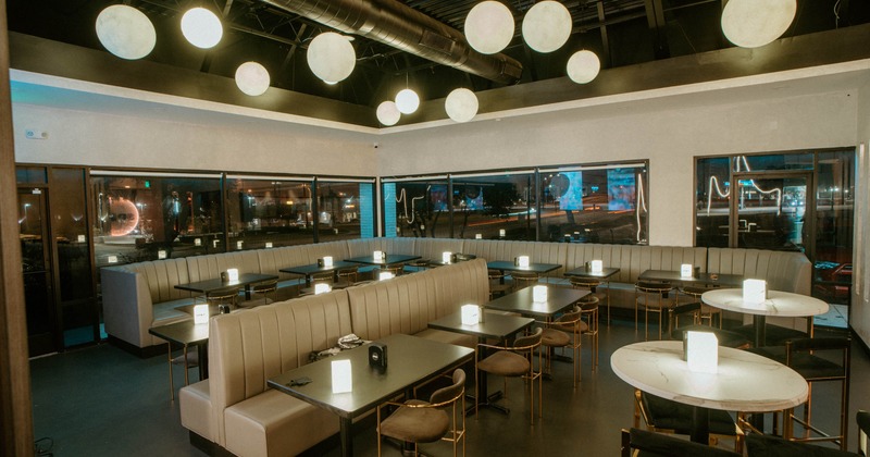 Interior, dining area, padded banquette benches with tables and chairs, round chandeliers