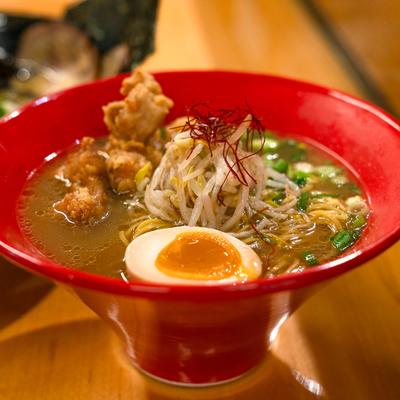 Chicken ramen bowl, with soft boiled egg, scallions, garlic, sesame seeds, and peppers.