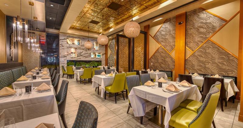 Interior of modern and cozy dining area with dining tables set for guests