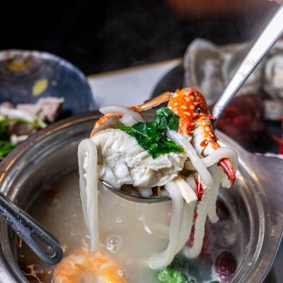 Seafood based hotpot featuring thick noodles, crab and greens.