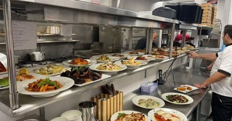 Busy kitchen counter filled with plated dishes