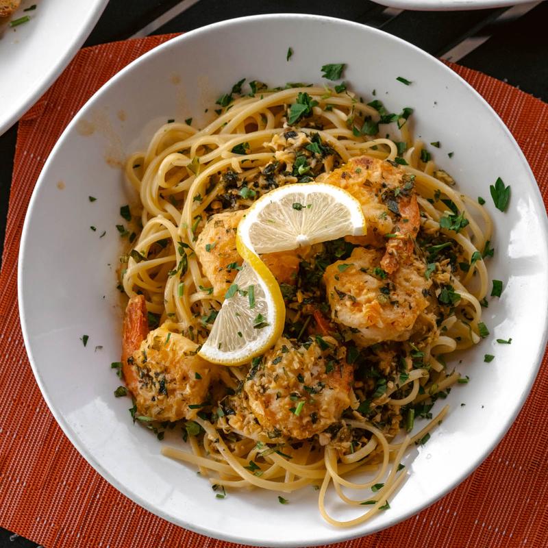 Spaghetti accompanied with shrimp and a lemon slice