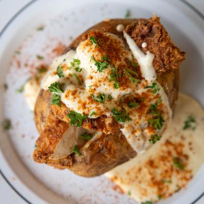 Baked potato stuffed with fried chicken, ranch, herbs, and spices.