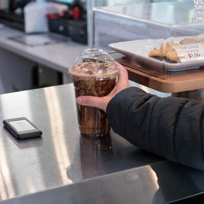 A hand reaching for a cup of coffee.