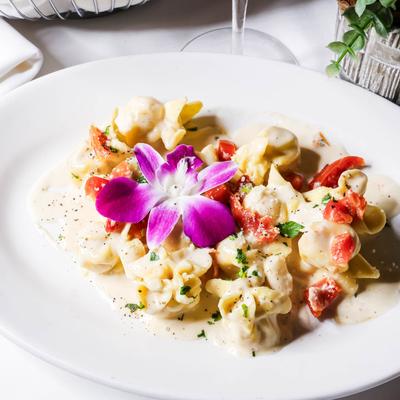 Pasta stuffed with pear and four cheeses with white cream sauce and sun-dried tomatoes.