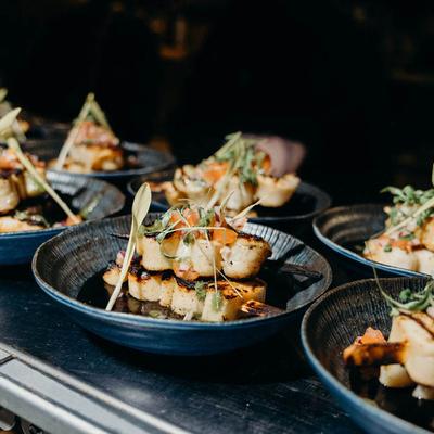 Bowls of grilled scallops garnished with microgreens.