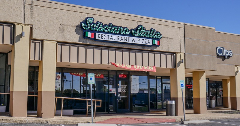 Exterior, front view to entrance, part of parking lot