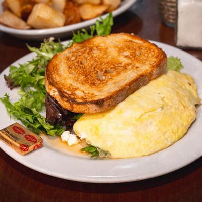 Goat cheese and spinach omelet served with toast, butter, and lettuce.