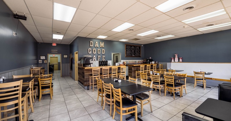 Interior of a cafe with wooden chairs, tiled flooring, a wooden counter