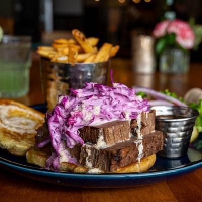 Braised brisket sandwich, with purple coleslaw, lettuce, tomato, onion and fries