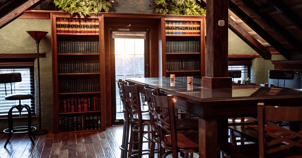 Loft seating area, tables and chairs, bookshelves in the back