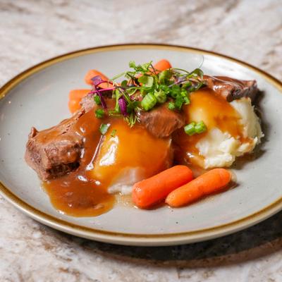 Pot roast served with gravy and sides.
