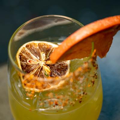 Paloma Sabrosa, garnished with dried orange and lemon slices and a chili-salt rim.
