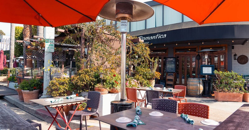 Exterior seating area with chairs and tables beneath parasols
