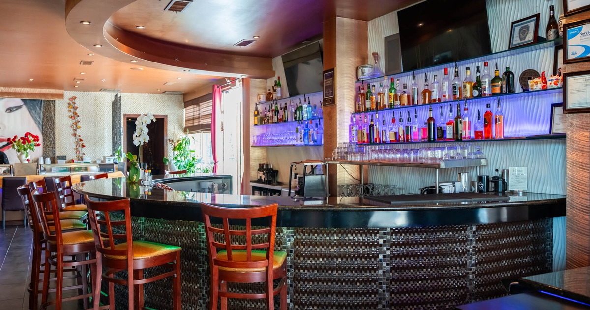 Interior, bar area, marble top bar and wooden stools with padded seat, drink shelf