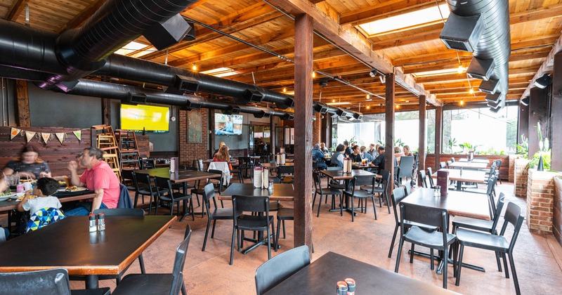 Interior, tables, chairs, customers sitting, windows, wall TVs