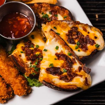 Munchie mania platter with potato skins, dipping sauce and various items.