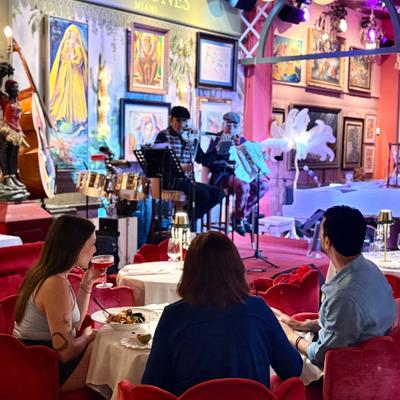Three people at the table eating while the band “puño cerrado” is playing.