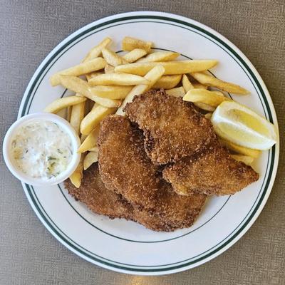 Fried Fish and french fries along with lemon wedge and coleslaw.