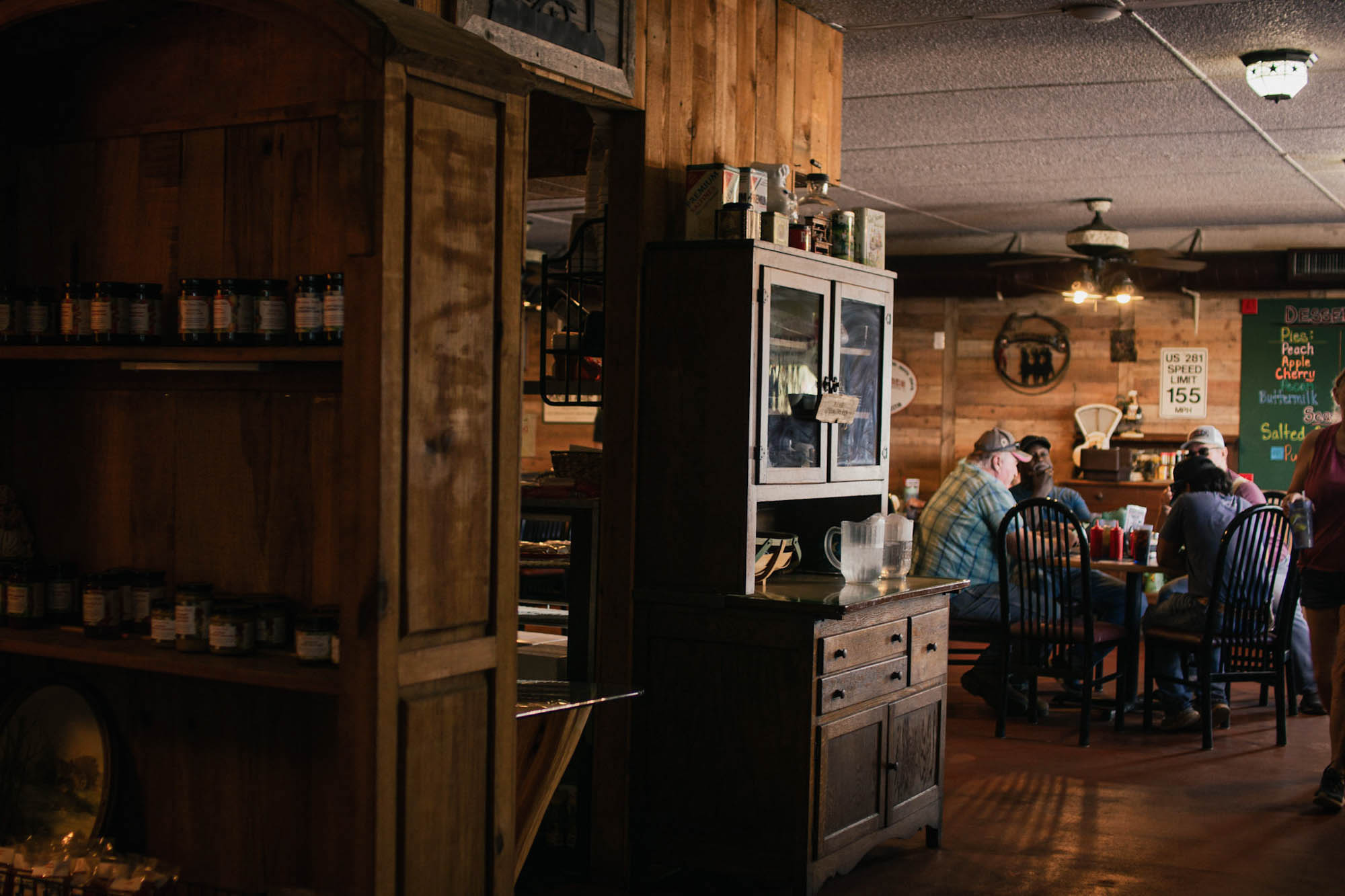 Image of a cupboard inside the Hill Country cupboard.  There are customers sitting in the background.