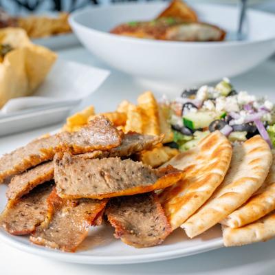 Beef Souvlaki Plate on a table with other dishes in the background.