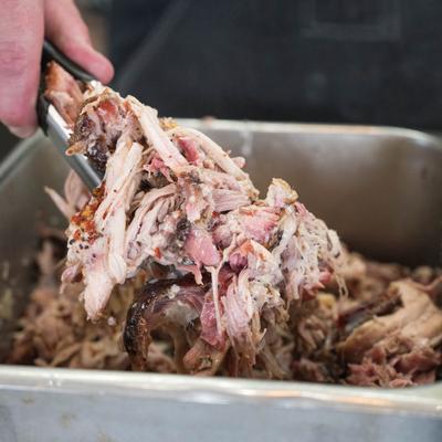 A hand serving pulled pork.