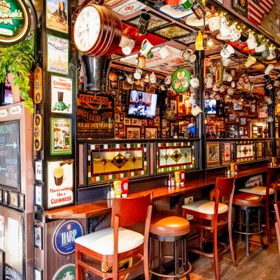 Bar interior with stools and wall covered in decor.