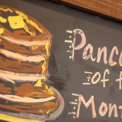 A drawing of pancakes on a black board.