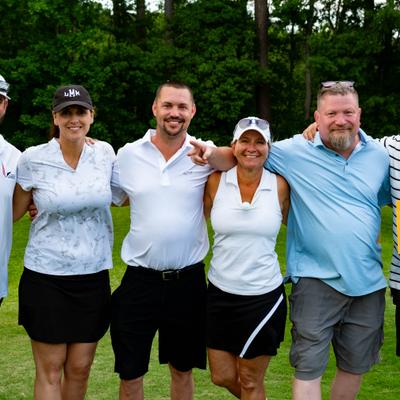 Group of people posing during a golf event.