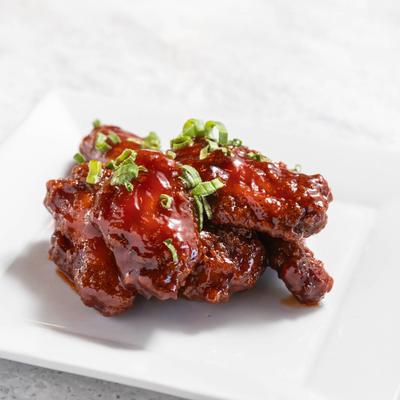 Fried chicken wings covered in a house-made mambo sauce and scallions.
