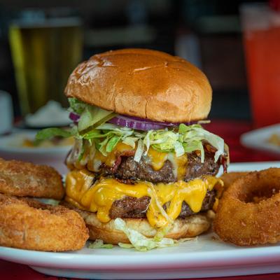 Big Mav Burger featuring two beef patties covered in cheese and a side of onion rings.