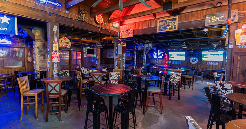 Interior, wooden decor, neon signs, and a ceiling fan, featuring wooden tables and chairs