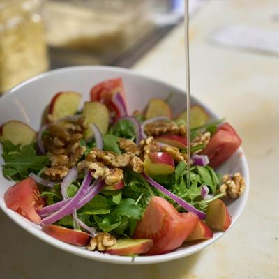 Green salad with walnuts, apples, and tomato wedges.